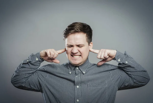 Genç adam duymak istemediği şeyleri gösteriyor. Parmakları kulaklarında