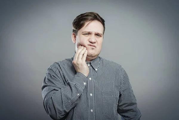 Genç bir adam diş ağrısı hisseder.