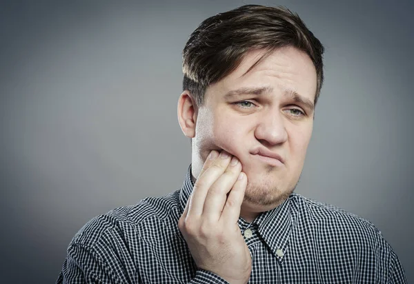 a young man feels toothache