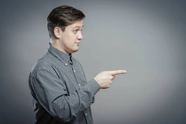 Genç adam parmağıyla birini işaret ediyor.