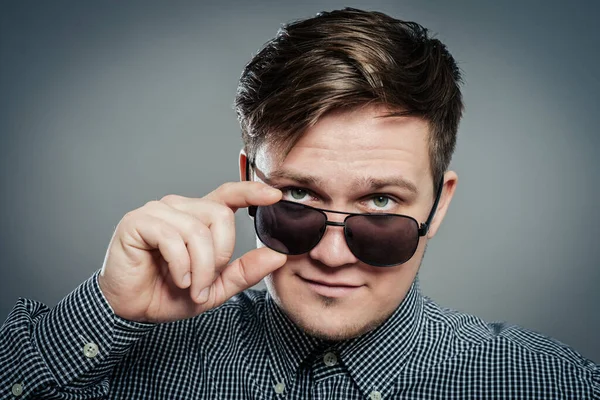 Gözlüklü genç çekici adamın stüdyo fotoğrafı.