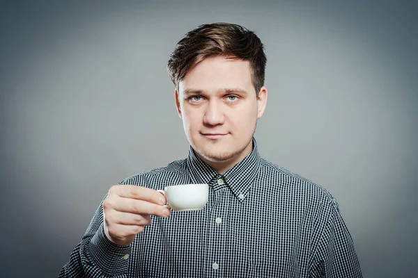 Kahve fincanıyla dinlenen yetişkin bir adamın görüntüsü.