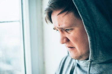 Depresyon, acı ve duygusal bozukluk, keder ve çaresizlik içinde tehlikeli ve yeraltında görünen kapüşonlu genç adam. 