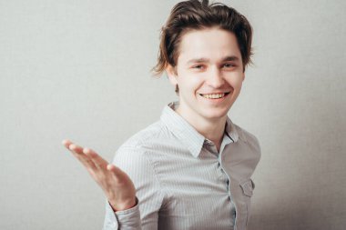 Genç adam bir şeyi açıklıyor, el kol hareketi yaparak.