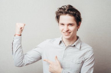 Genç adam kaslarını gösteriyor.