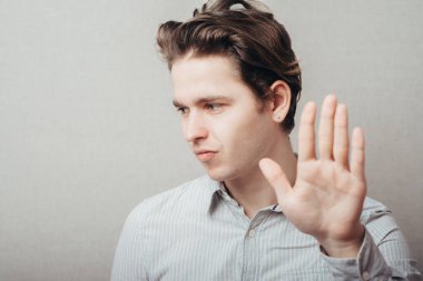 Genç bir adam elleriyle durduruyor.