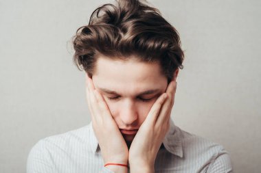 Elleri yüzü asık genç bir adam.