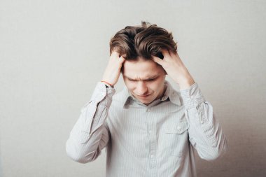 Ellerini kulaklarının üzerinde tutan bir adam.