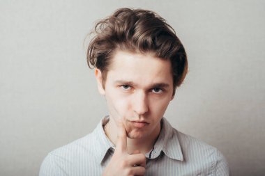 Genç adam fotoğraf stüdyosunda düşünüyor.