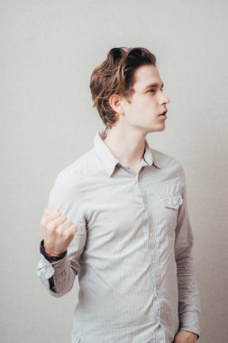 Yakın plan portre, sinirli sinirli sinirli genç adam kamera karşısında sana yumruk sallıyor. Negatif insani duygu yüz ifadesi çatışma hissi