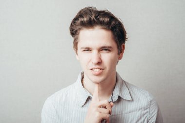 Adam düşünüyor ve çenesinin altında parmağını tutuyor.