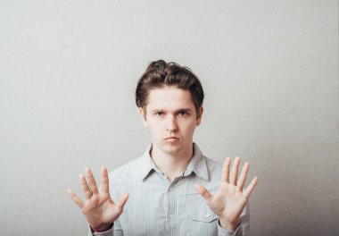 Genç adam durduğunu göstermek için kollarını kavuşturdu.