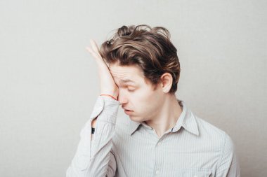 Genç adam yorgun gözlerle ovalıyor.