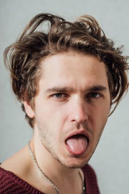 Genç adam dil gösteriyor.