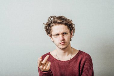 Şiddetli kötü niyetli genç adam kamerayı işaret ediyor..