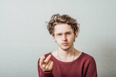 Şiddetli kötü niyetli genç adam kamerayı işaret ediyor..