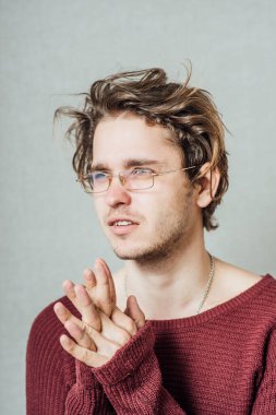 Gözlüklü adam birlikte dua ediyor. Gri bir arkaplanda.