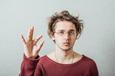 Gözlüklü adam biraz kendini gösteriyor. Gri bir arkaplanda.