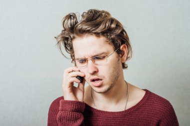 Telefondaki adam konuşuyor. Gri bir arkaplanda.