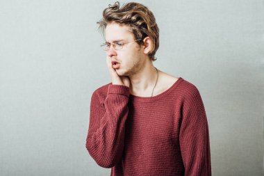 Erkek diş ağrısı. Gri bir arkaplanda.