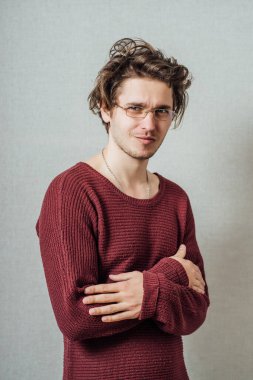 Kollarını kavuşturmuş, gülümseyen bir adamın portresi..