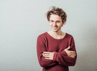 Kollarını kavuşturmuş, gülümseyen bir adamın portresi..