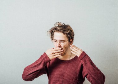 Uykulu genç adam esniyor.