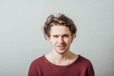 Closeup portret van een gelukkige jonge man die lacht op grijze achtergrond