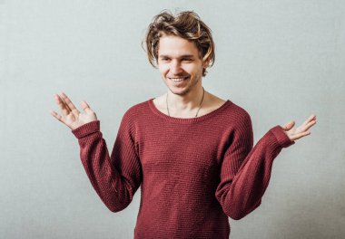 Yüzünde bir gülümseme ve kolları açık genç bir adam.