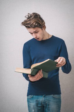 Kitap okuyan yakışıklı bir genç adam.