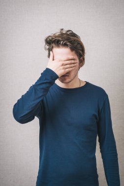 Genç adam gözlerini kapatıyor.