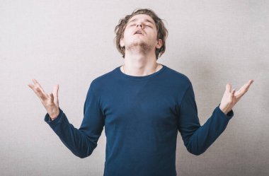 Genç adam arka planda dua ediyor.