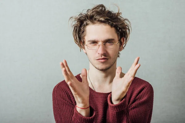 Gözlüklü adam elinde bir şey tutuyor.