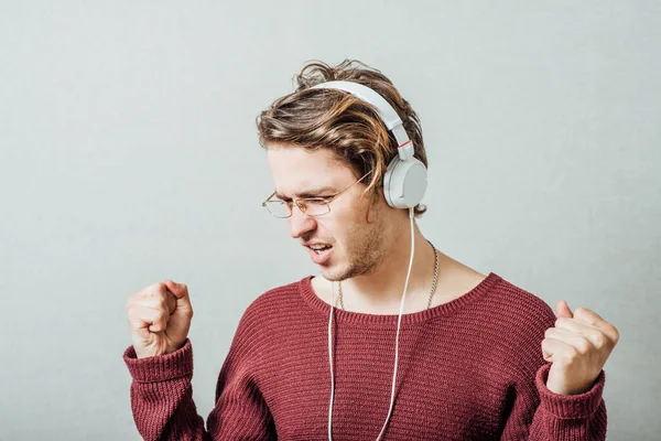 Egy Férfi Fülhallgatóban Zenét Hallgat Szürke Háttérrel — Stock Fotó