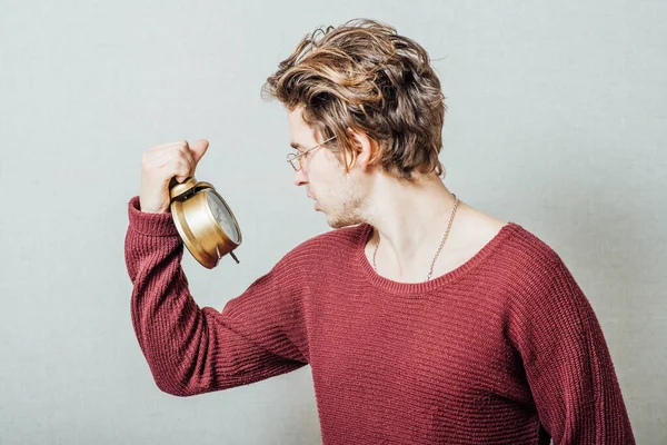 Elinde çalar saati tutan bir adam