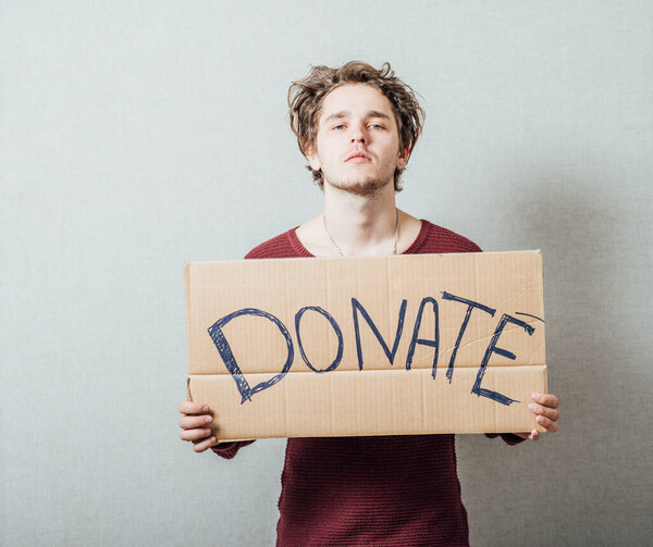 man, holding a picture with the inscription donate