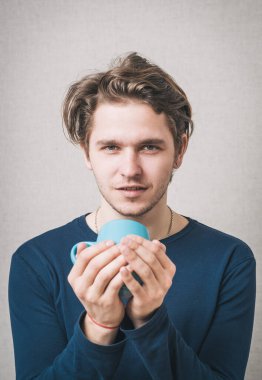 Elinde bardak tutan adam.