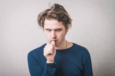 Adam tırnaklarını yer ve düşünür.