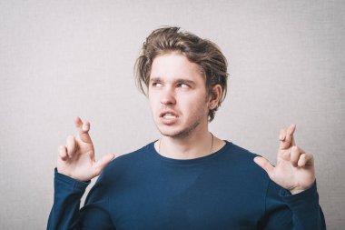 Adam şans için dua etti. Gri arkaplan