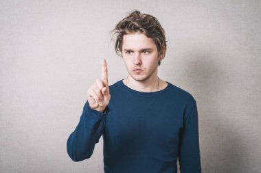 İşaret parmağı yukarı. Gri arkaplan.