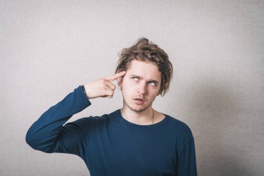 Adam baş ağrısı olduğunu düşünüyor. Gri arkaplan.