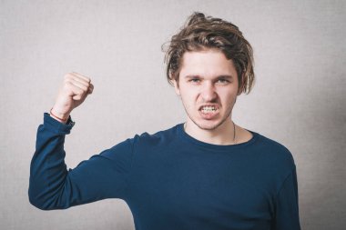 Bir adam kolunun gücünü gösterir. Gri arkaplan.