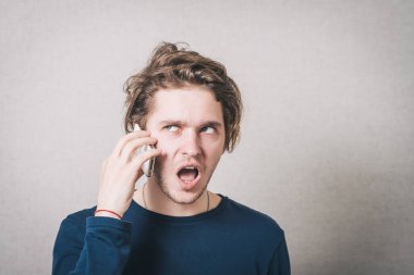 Telefondaki adam konuşuyor. Gri arkaplan.