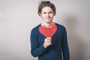 Kırmızı kalpli bir adam. Gri arkaplan.