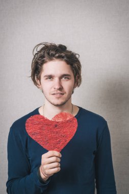 Kırmızı kalpli bir adam. Gri arkaplan.
