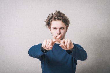 X parmak gösteren bir adam. Gri arkaplan.