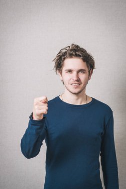 Adam incir gösteriyor. Gri arkaplan.