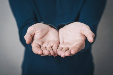 Boş eller gösteren bir adam. Gri arkaplan