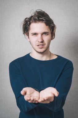 Boş eller gösteren bir adam. Gri arkaplan