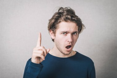 İşaret parmağı gösteren bir adam. Gri arkaplan